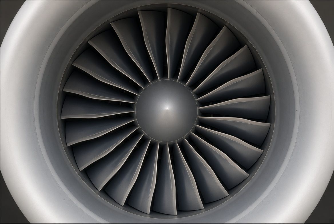 Close-up of a jet engine's front fan blades and center spinner